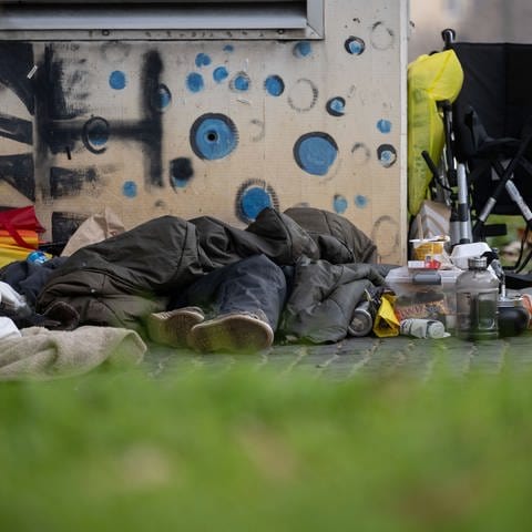 Eine Person liegt in der Innenstadt unter einem Schlafsack. - In Rheinland-Pfalz gibt es drei "Housing-First-Projekte". Jetzt wurde eine erste Bilanz gezogen. (Foto: dpa Bildfunk, picture alliance/dpa | Marijan Murat)
