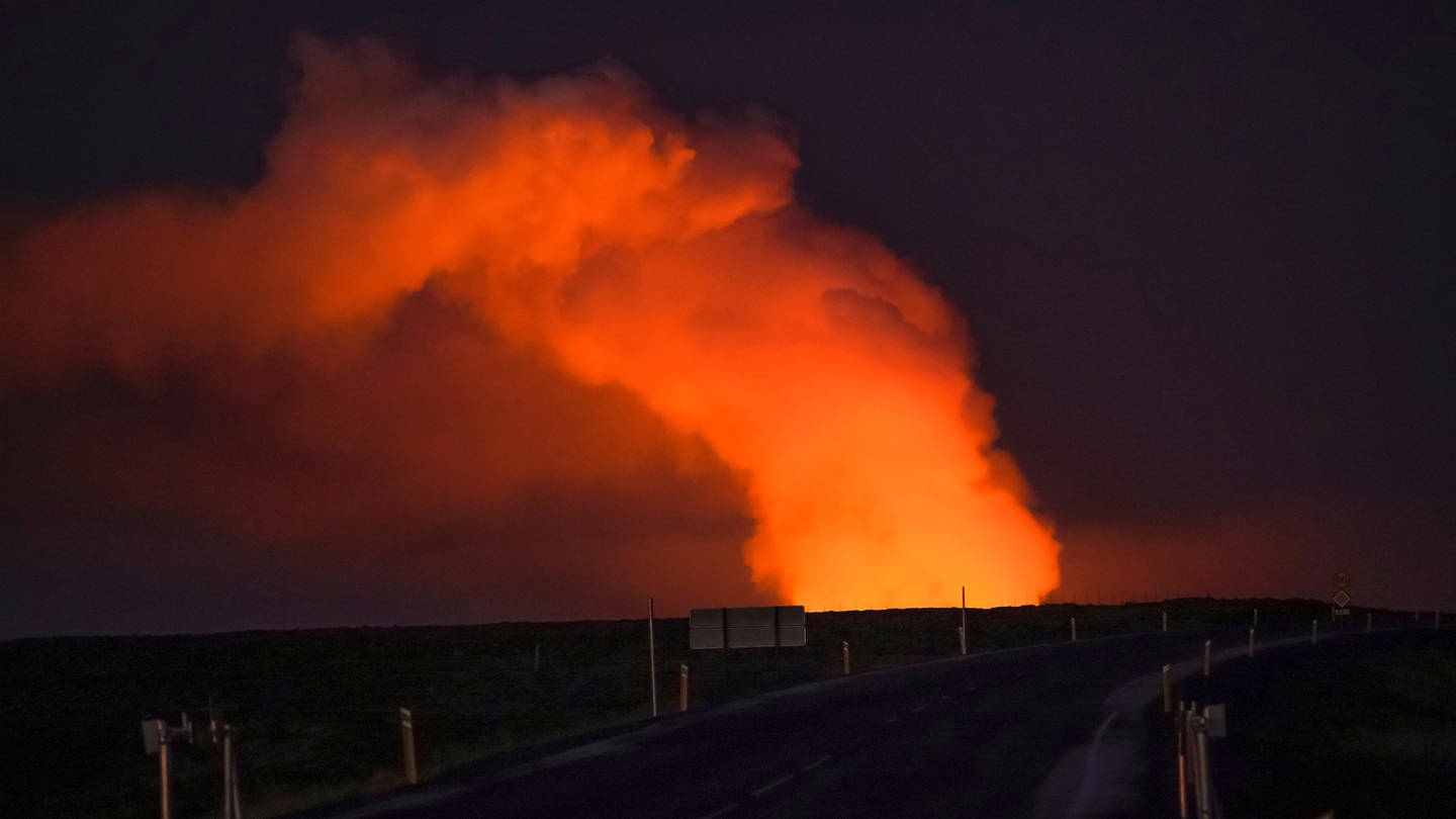 Blick auf die Gaswolke, die von der Lava des ausbrechenden Vulkans beleuchtet wird, von der Straße Suðurstrandavegur aus gesehen, die nach Grindavík in Island führt. Auf Island hat der zweite Vulkanausbruch innerhalb weniger Wochen begonnen. (Foto: dpa Bildfunk, picture alliance/dpa/AP | Marco Di Marco)