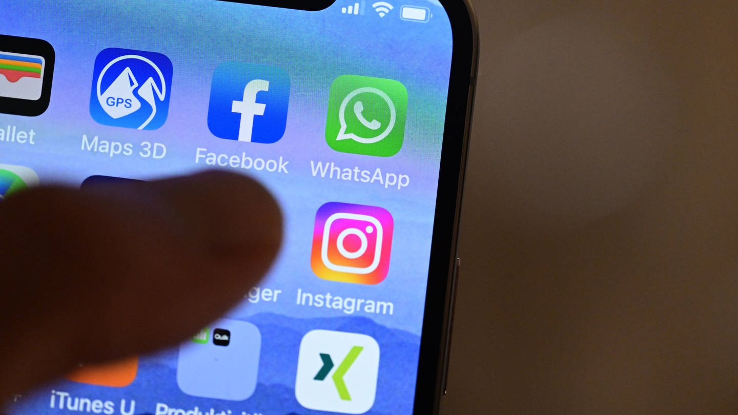 Eine Hand hält ein iPhone, auf dem Sozial Media Apps dargestellt sind. Eine aktuelle Studie zeigt, dass Menschen in Deutschland immer mehr Zeit online verbringen. (Foto: dpa Bildfunk, picture alliance/dpa | Bernd Weißbrod)