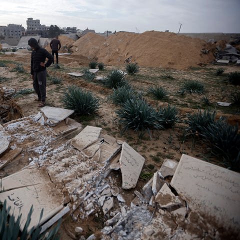 Palästinenser inspizieren beschädigte Gräber nach einem israelischen Panzerangriff auf einen Friedhof im Flüchtlingslager Chan Junis im südlichen Gazastreifen. (Symbolbild) (Foto: dpa Bildfunk, picture alliance/dpa/AP | Mohammed Dahman)