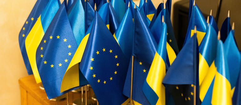 Kleine ukrainische und europäische Flaggen sind auf einem Tisch zu sehen (Foto: dpa Bildfunk, picture alliance/dpa/dpa-ENR-Pool | Philipp von Ditfurth)