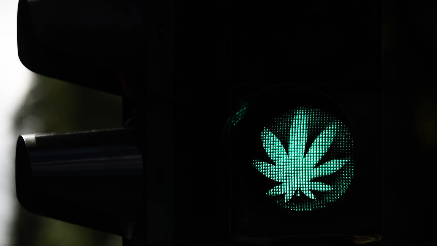 Ein Cannabis-Blatt leuchtet während der Grünphase an einer Ampel. Die Cannabis-Legalisierung in Deutschland kann kommen. Jetzt müssen noch Bundesrat und Bundestag zustimmen. (Foto: dpa Bildfunk, picture alliance/dpa | Rolf Vennenbernd)