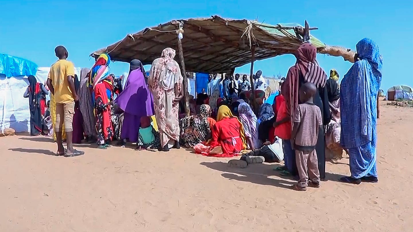 Sudanesische Geflüchtete versammeln sich vor einem Feldlazarett. Seit Mitte April kämpfen im Sudan die Streitkräfte unter der Führung des amtierenden Staatschefs Abdel Fattah al-Burhan gegen die paramilitärischen RSF. Nach UN-Angaben sind mehr als sieben Millionen Menschen im Land auf der Flucht. (Foto: dpa Bildfunk, picture alliance/dpa/AP | Uncredited)