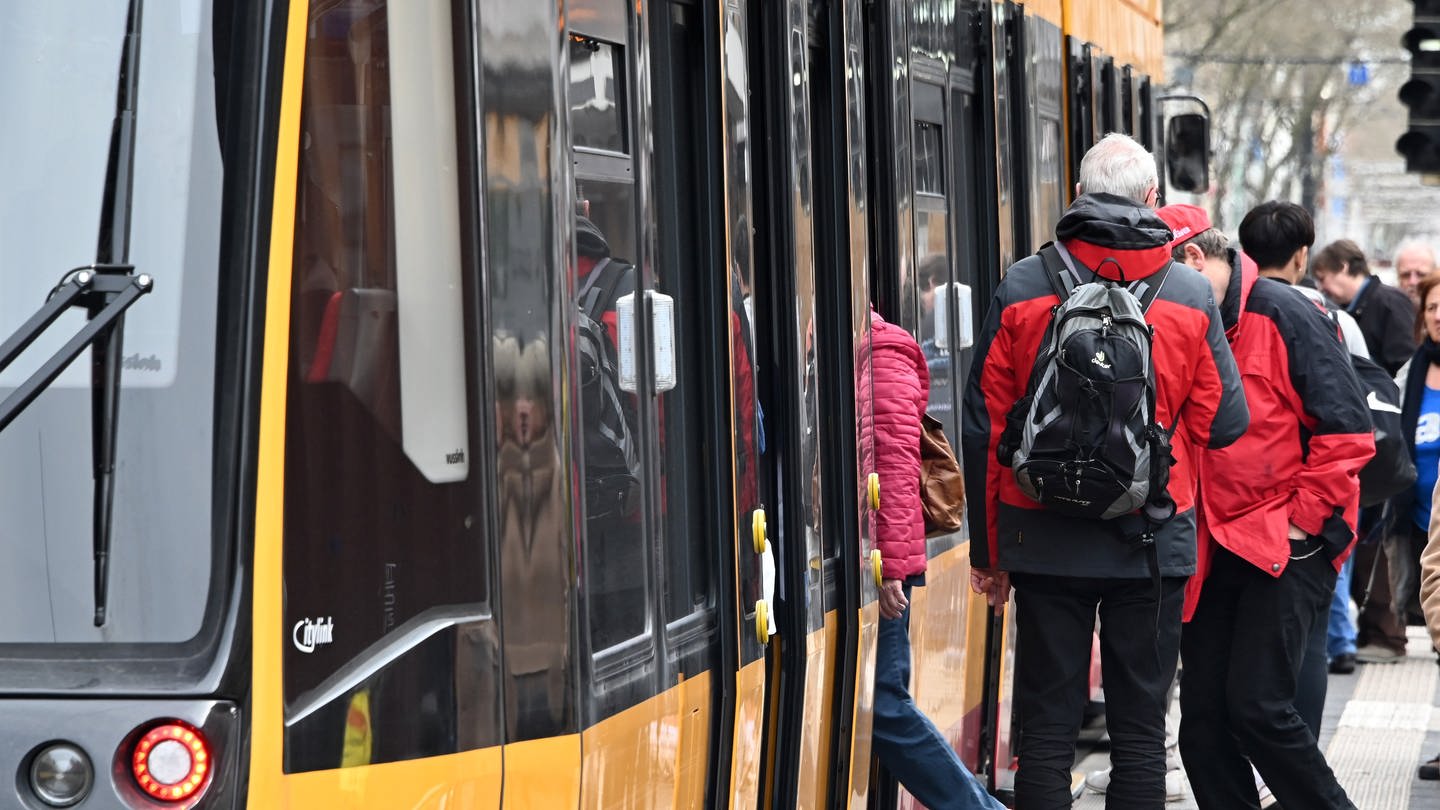 In der Innenstadt steigen Fahrgäste in eine Strassenbahn ein. (Foto: dpa Bildfunk, picture alliance/dpa | Uli Deck)