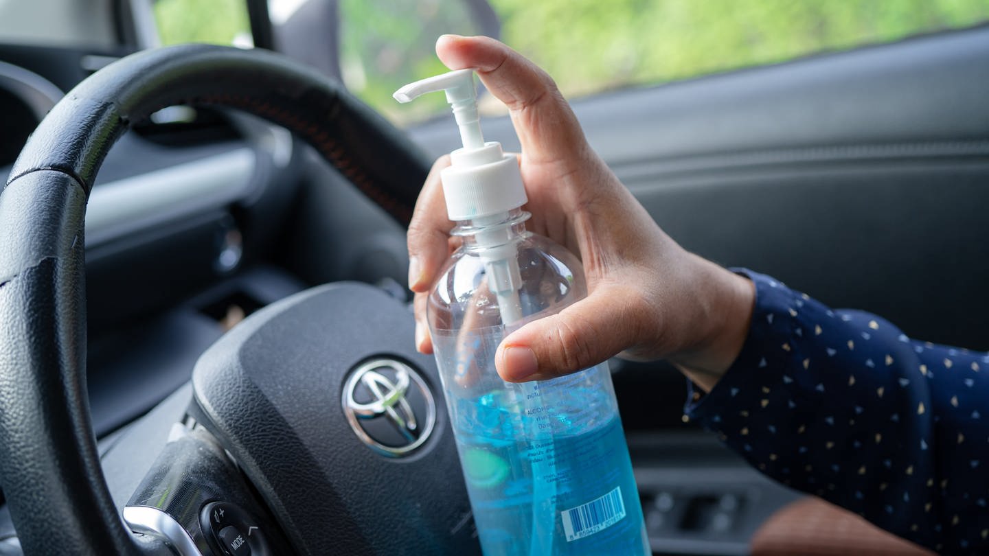 Ein Autofahrer hat Desinfektionsmittel in der Hand. (Foto: IMAGO, IMAGO / Panthermedia)