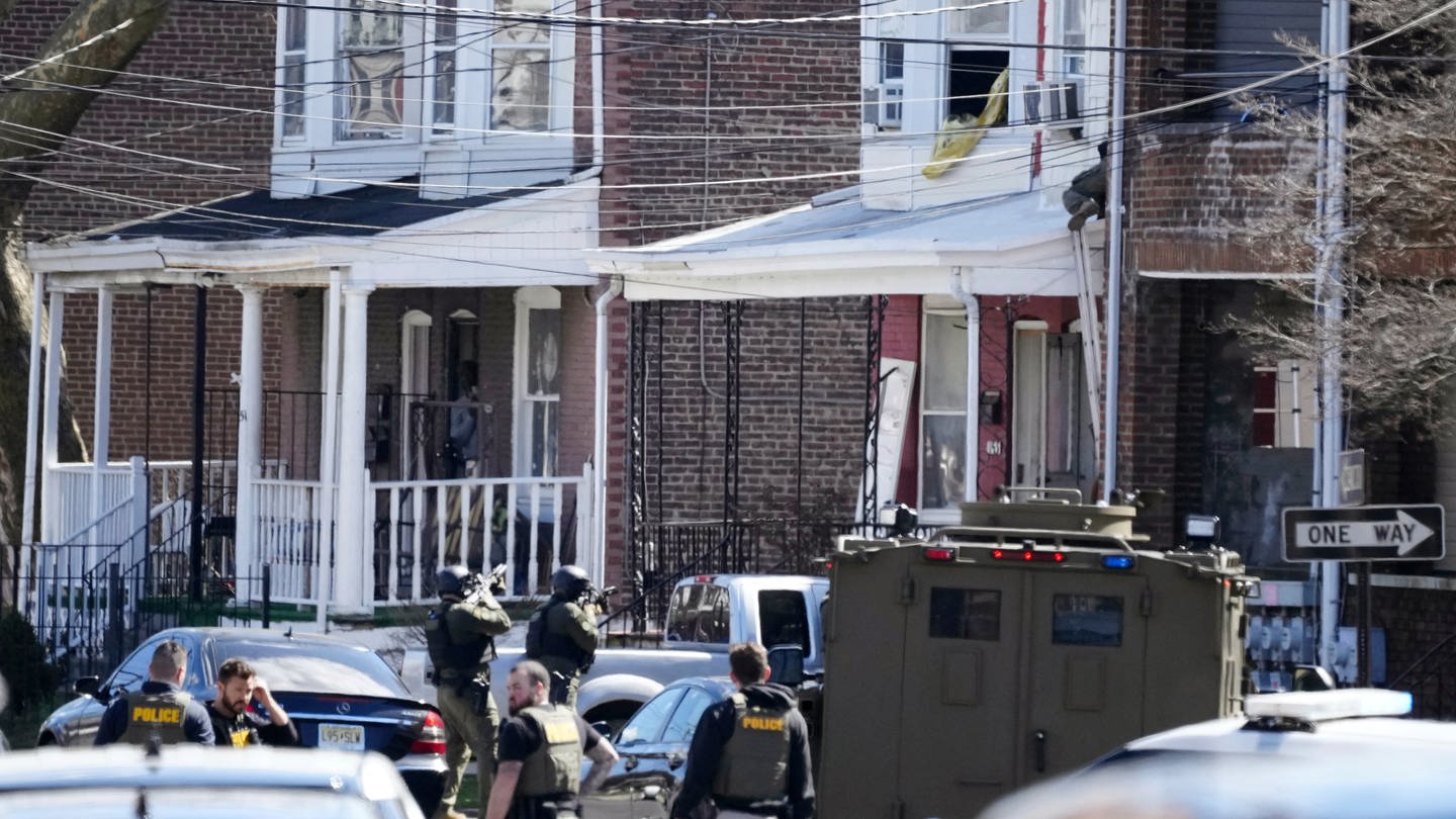 Polizisten umstellen ein Haus. Ein Verdächtiger hatte sich in dem Haus verbarrikadiert und Geiseln genommen, nachdem er in einem Vorort von Philadelphia drei Menschen erschossen hatte. (Foto: dpa Bildfunk, picture alliance/dpa/AP | Matt Rourke)