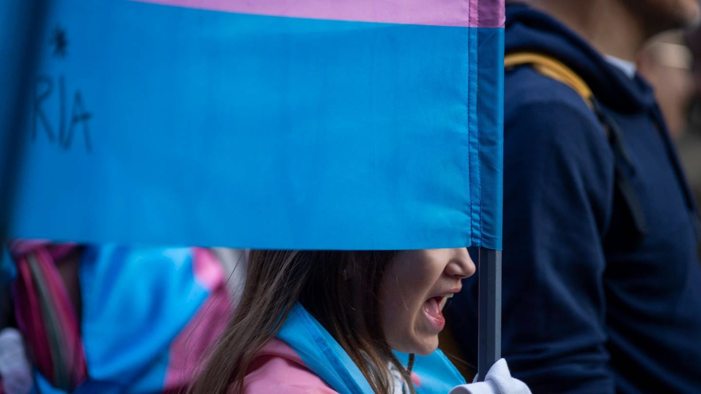Symbolbild: Junge Person mit Trans-Flagge auf einer Demo in Madrid. (Foto: dpa Bildfunk, IMAGO / ZUMA Wire)