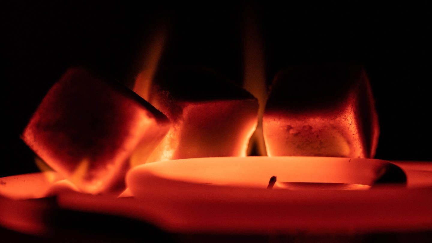 Glühende Shisha-Kohle liegt auf Kohlenanzünder in einer Wohnung. (Foto: IMAGO, IMAGO / Silas Stein)