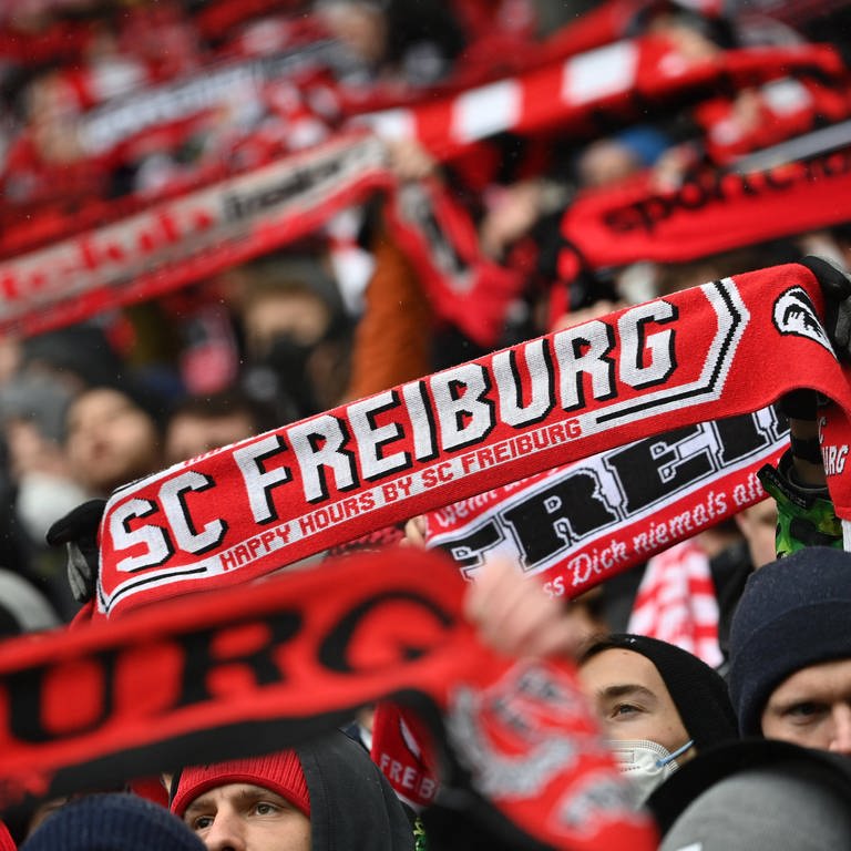 Ein Fan hält einen Schal vom SC Freiburg in die Höhe