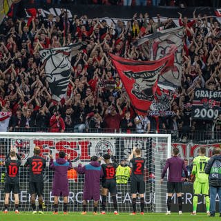 Die Mannschaft von Bayer Leverkusen feiert Sieg vor der Kurver der Fans: Am Wochenende könnte Bayer Meister werden. (Foto: IMAGO, IMAGO / Nordphoto)