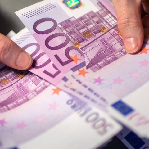 Eine Frau zählt 500-Euro-Scheine