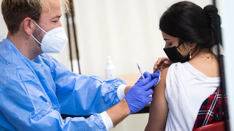 Eine Schülerin lässt sich bei einer Impfaktion des Malteser Hilfsdienstes an der Ruth-Cohn-Schule in Berlin-Charlottenburg gegen Corona impfen