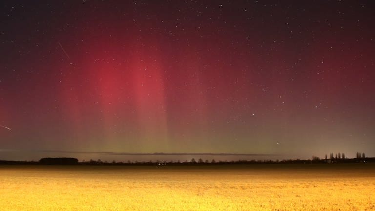 Polarlichter leuchten über Brandenburg auf dieser Nachtaufnahme mit Langzeitbelichtung. Eine starke Eruption auf der Sonne hat zu den roten und grünen Leuchteffekten in der Atmosphäre geführt, die man sonst nur im nördlichen Skandinavien oder auf Island sehen kann.