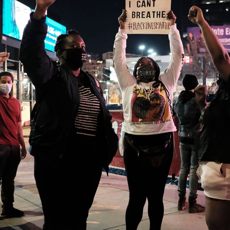 USA: Eine Gruppe von Demonstranten mit erhobenen Fäusten, einer hält ein Schild mit der Aufschrift I CAN T BREATHE BLACKLIVESMATTER