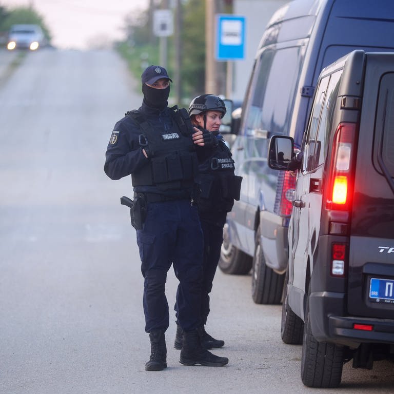 Polizeibeamte stehen auf einer Straße im Dorf Dubona, etwa 50 Kilometer südlich von Belgrad, während sie die Straße in der Nähe des Tatorts eines Anschlags sperren. (Foto: dpa Bildfunk, picture alliance/dpa/AP | Armin Durgut)
