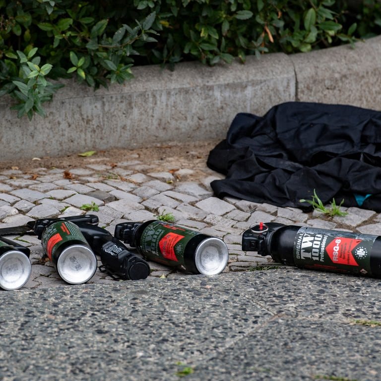 Mehrere Reizgasflaschen liegen auf dem Boden  (Foto: dpa Bildfunk, picture alliance/dpa | Paul Zinken)