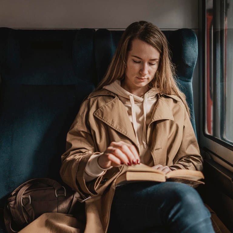 Eine junge Frau sitzt in einem Zug. Über das Pfingstwochenende 2023 wird es laut der Deutschen Bahn keine Streiks geben. (Foto: Freepic.com)