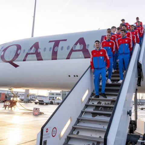 Die Spieler von FC Bayern München stehen auf der Treppe eines Flugzeugs der Fluglinie Qatar Airways. Die Zusammenarbeit zwischen dem Fußballverein und der Airline wird jetzt beendet.