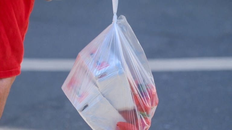 Dünne Plastiktüte mit Erdbeeren. Neuseeland verbietet dünne Plastiktüten und Einweggeschirr- sowie -Besteck.
