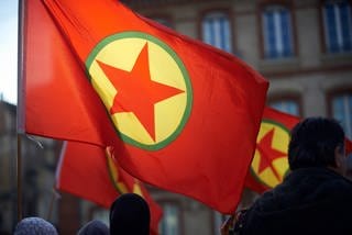 Flagge der verbotenen, kurdischen Arbeiterpartei PKK auf einer Demonstration.