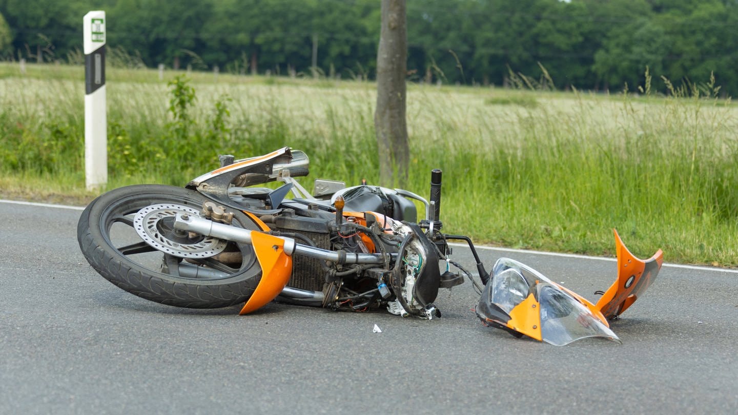 Ein Motorrad liegt nach einem Unfall auf einer Straße (Symbolbild). (Foto: IMAGO, Fotostand (Symbolbild))
