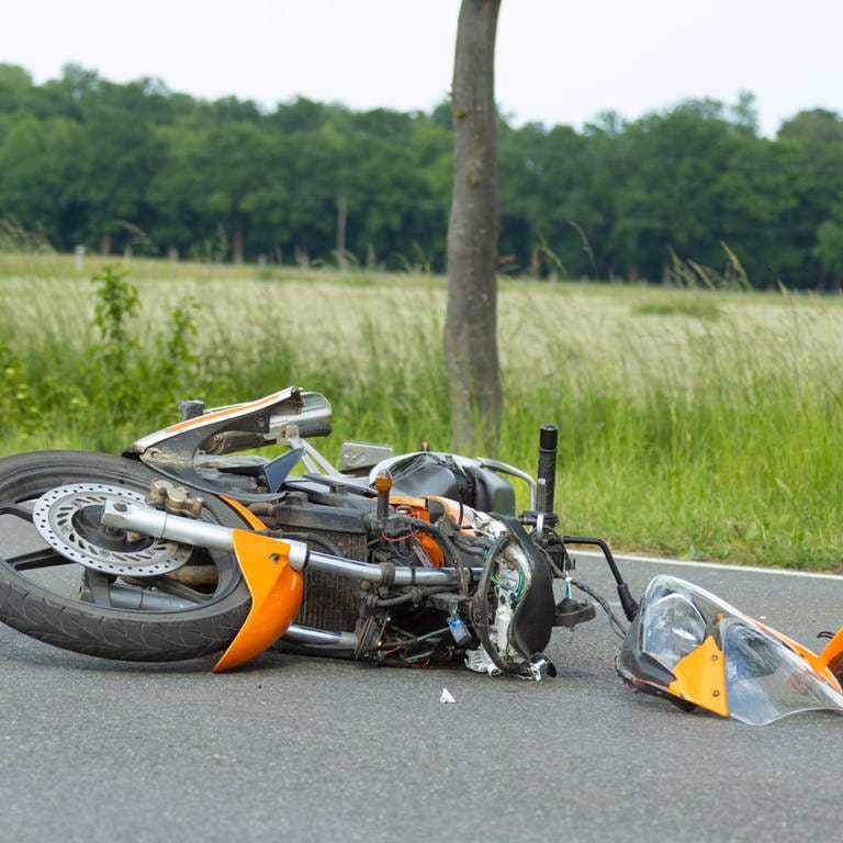Ein Motorrad liegt nach einem Unfall auf einer Straße (Symbolbild). (Foto: IMAGO, Fotostand (Symbolbild))