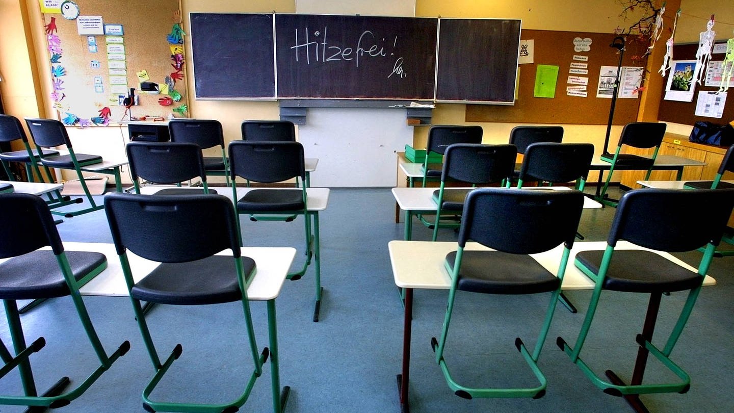 Ein leeres Klassenzimmer in einer Schule. Auf der Tafel steht 