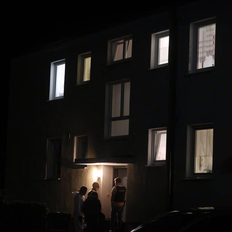 Polizisten und Beamte der Spurensicherung stehen vor dem Haus in Langweid bei Augsburg, in dem drei Menschen erschossen worden sind.