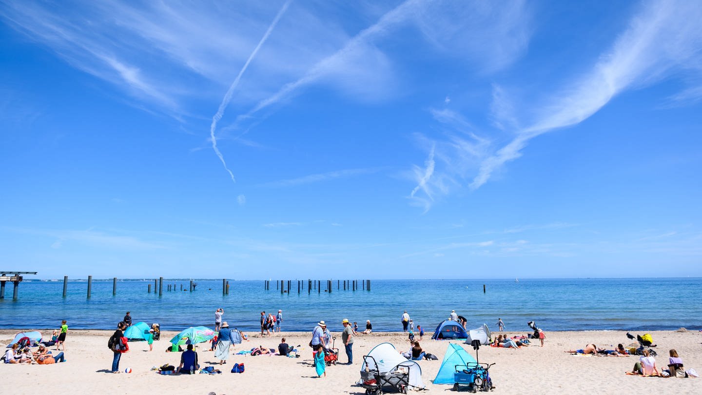 Menschen genießen das Wetter und ihren Urlaub am Strand an der Ostsee. (Foto: dpa Bildfunk, picture alliance/dpa | Jonas Walzberg)