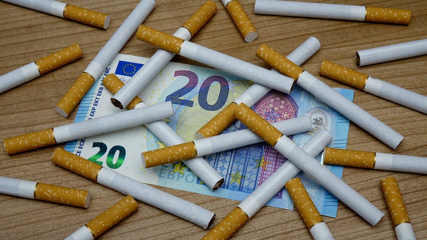 Zigaretten liegen auf einem 20-Euro-Schein (Foto: IMAGO, IMAGO/Steinach)