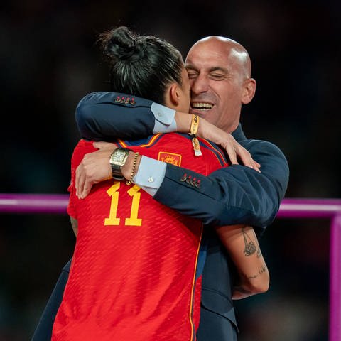 FIFA Frauen-Weltmeisterschaft 2023: Der spanische Verbandspräsident Luis Rubiales nimmt die Spielerin Jennifer Hermoso in den Arm nach ihrem WM-Sieg. Rubiales wird kritisiert, weil er Hermoso während der Siegerehrung auf den Mund geküsst hat. Sie hat darüber danach gesagt, dass es ihr nicht gefallen habe.