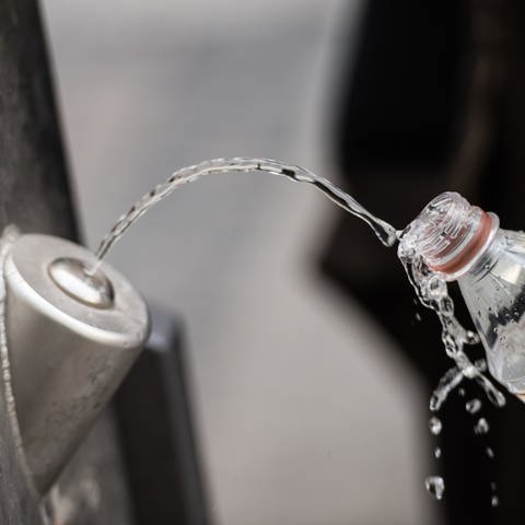  FrankfurtMain: Ein Mann füllt sich an einem Brunnen kostenlos Trinkwasser in die eigene Flasche. In Mainz wurde der erste Trinkwasserspender in Betrieb genommen.