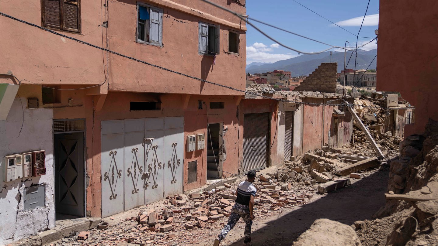 Ein Mann rennt in der Stadt Amizmiz in der Nähe von Marrakesch, um Gegenstände aus seinem Haus zu bergen. In Marokko ist es zu einem heftigen Erdbeben gekommen. (Foto: dpa Bildfunk, picture alliance/dpa/AP | Mosa'ab Elshamy)