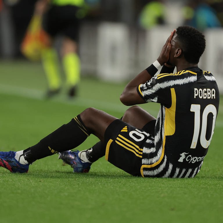 Der verletzte Paul Pogba von Juventus hält sich die Hände vor das Gesicht und sietzt auf dem Spielfeld.