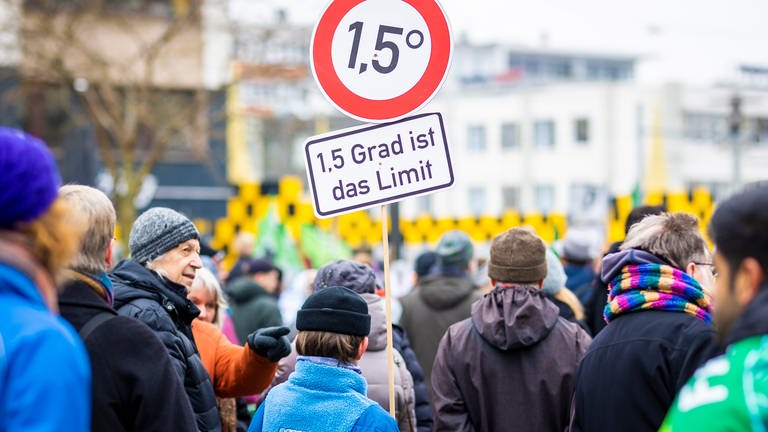 Der Schriftzug "1,5 Grad ist das Limit" ist auf einem Protestplakat zu lesen. Das erreichen der Kimaziele ist noch möglich, sagt die Internationale Energieagentur. (Foto: dpa Bildfunk, picture alliance/dpa | Moritz Frankenberg)