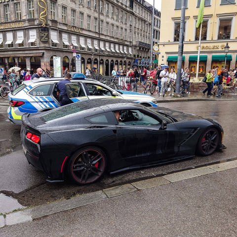 Ein Auto steht in München im Halteverbot und wird von der Polizei kontrolliert.
