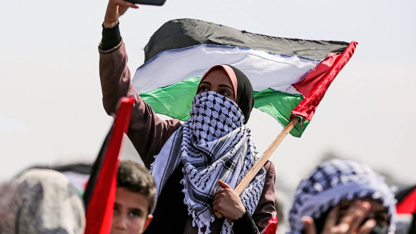 Palästinensische Frau hält Telefon auf Demo in Gaza (Foto: IMAGO, IMAGO / ZUMA Wire)