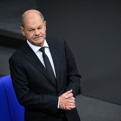 Bundeskanzler Olaf Scholz (SPD) steht zu Beginn der Plenarsitzung im Deutschen Bundestag.