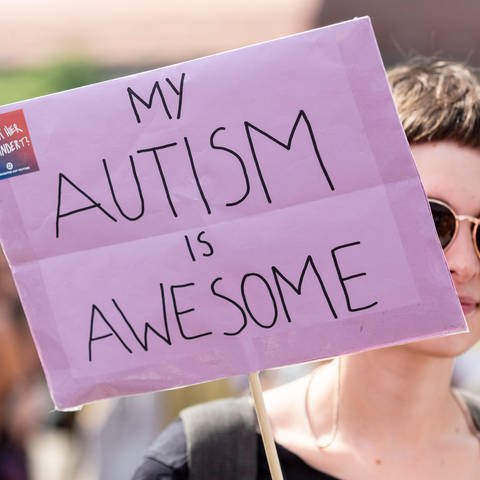 „Mein Autismus ist großartig" steht in englischer Sprache bei der Pride Parade 2019 auf dem Plakat einer Teilnehmerin. Die Teilnehmer protestieren gegen Benachteiligung.