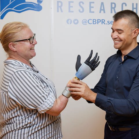 Testperson Karin mit Hand-Prothese und Professor Max Ortiz Catalán vom Bionics Institute