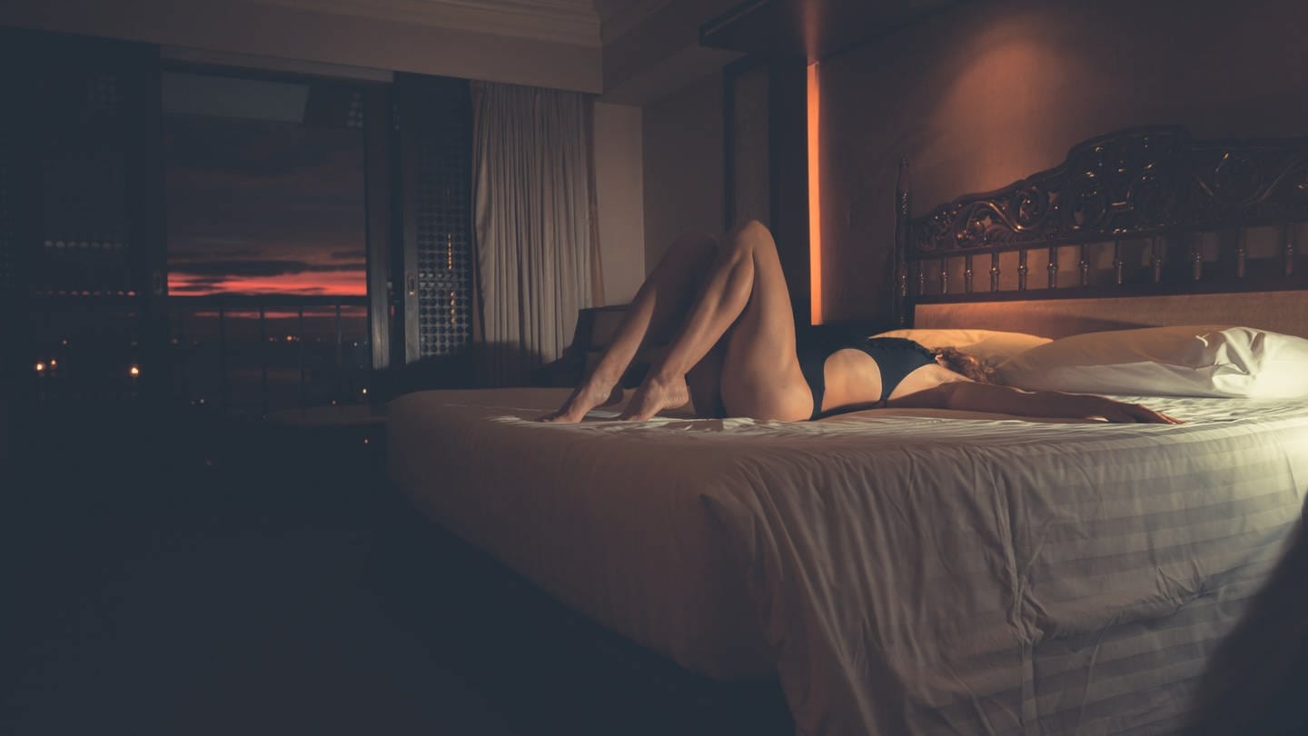 RECORD DATE NOT STATED A sexy young woman in a swimsuit is lying on a hotel room bed at sunset *** einer sexy Jung Frau ÊIn einer Badeanzug ist liegendes am einer Hotelbus Zimmer Bett im Sonnenuntergang ING_37571_03596 (Foto: IMAGO, IMAGO / ingimage)
