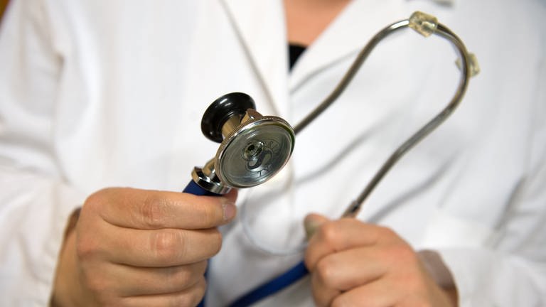 Eine Ärztin hält ein Stethoskop in der Hand. - In Baden-Württemberg müssen jetzt Notfallpraxen schließen oder ihre Öffnungszeiten stark einschränken.