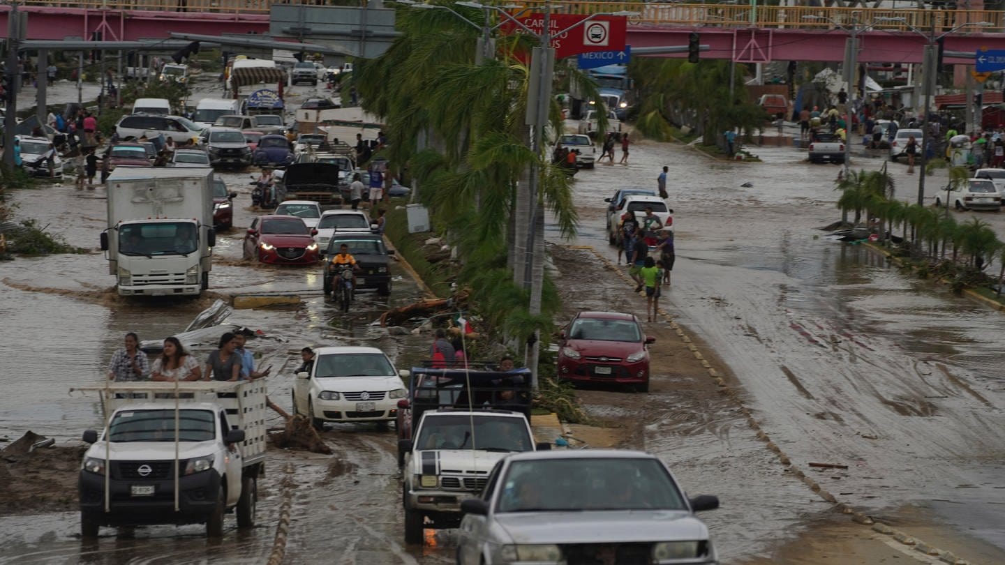 Autos überqueren eine überschwemmte Straße, nachdem Hurrikan 