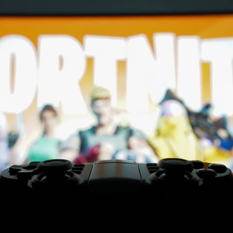 Spielkonsole und Fortnite-Screen im Hintergrund: Die neue Season Fortnite OG ist online - es ist eine Reise zu den Anfängen des Games.