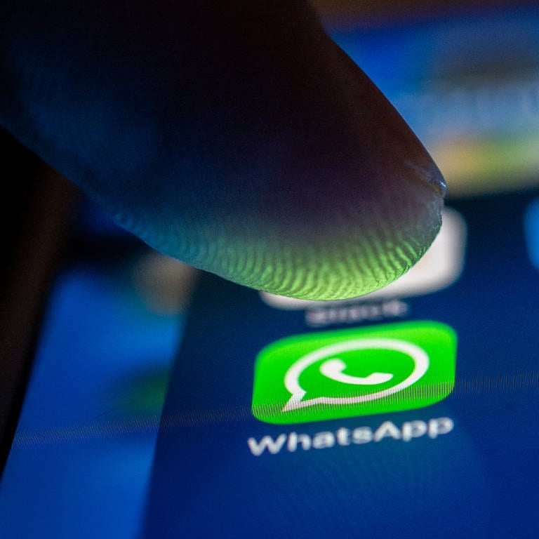 Ein Finger berührt das Whatsapp-Logo auf einem Smartphone. Das Backup könnte dich bald Geld kosten.