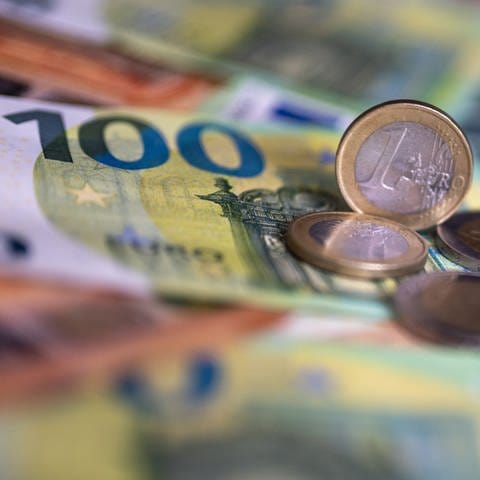 Geldscheine mit dem Wert von 100 und 50 Euro und Münzen liegen auf einem Tisch. - In Deutschland gibt es jetzt eine Haushaltssperre. Aber: Was bedeutet das?