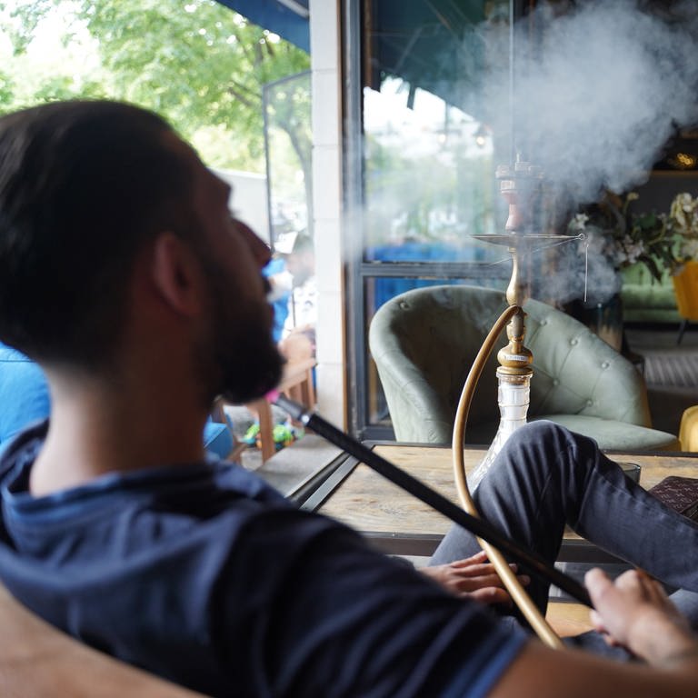 Ein junger Mann raucht eine Shisha in einer Shisha-Bar. (Foto: dpa Bildfunk, picture alliance/dpa | Jörg Carstensen)