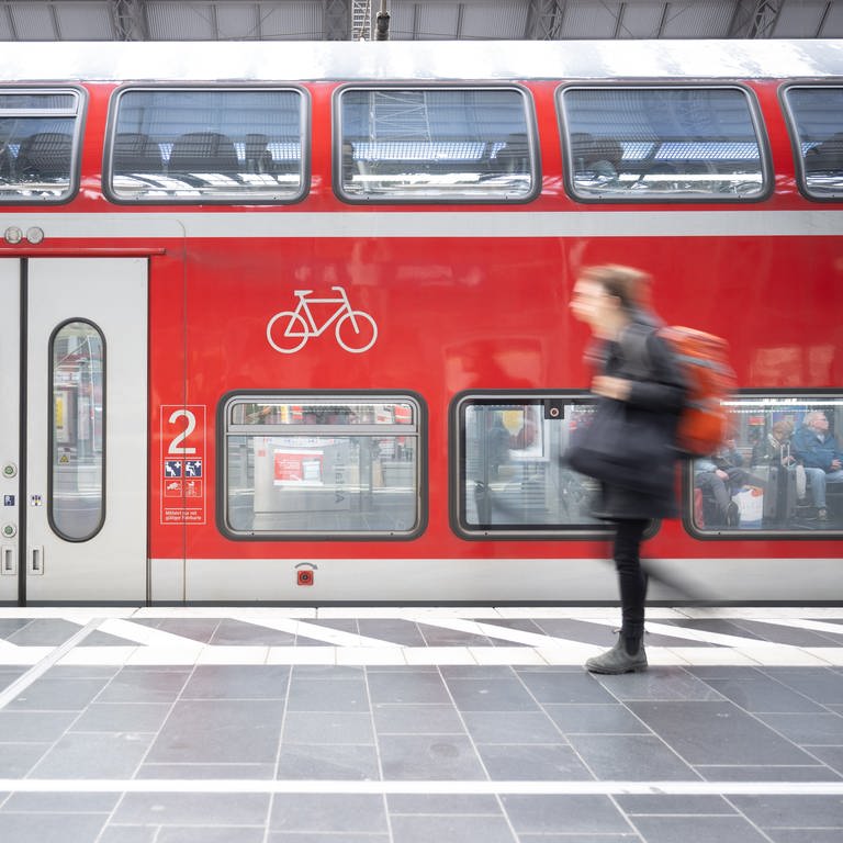 Eine Frau geht an einer Regionalbahn vorbei. Ab dem Sommersemester 2024 soll es ein Deutschlandticket für Studierende geben.