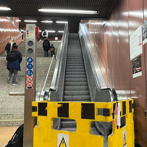 Stuttgart: An der S-Bahn-Haltestelle Universität ist eine Rolltreppe defekt. Fahrgäste reagieren mit Memes, die sie auf den Bauzaun kleben.