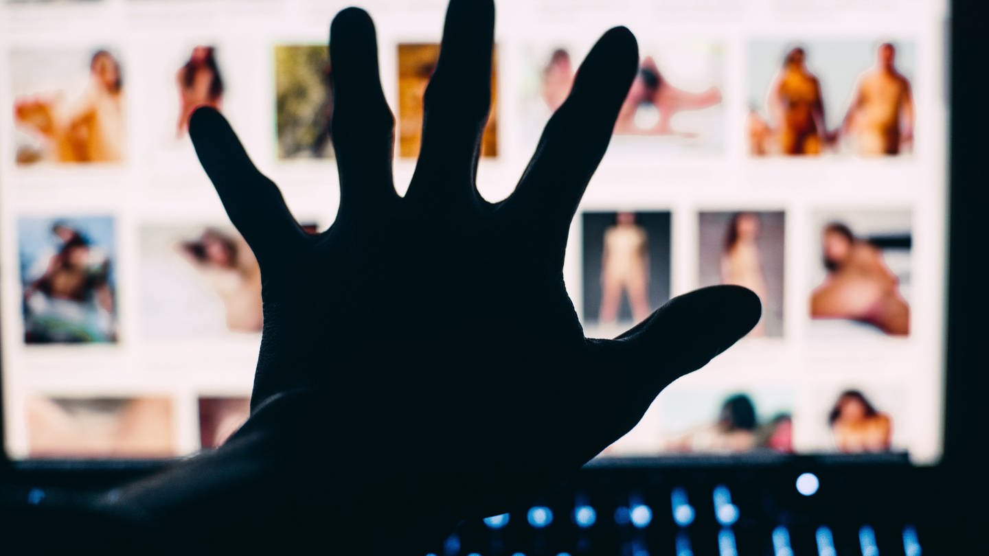 Hand verdeckt pornografische Inhalte im Internet (Foto: IMAGO, IMAGO / Wirestock)